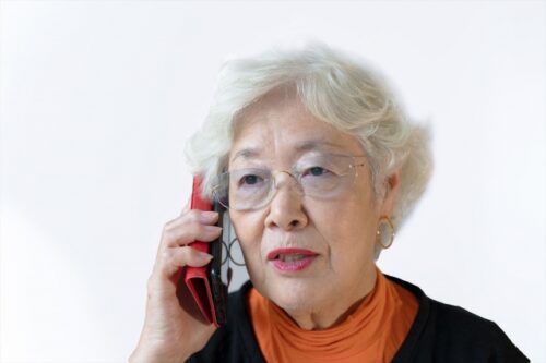 電話をかける高齢女性