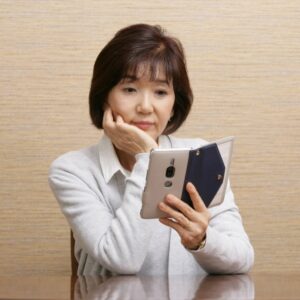 お葬式について調べる中年女性